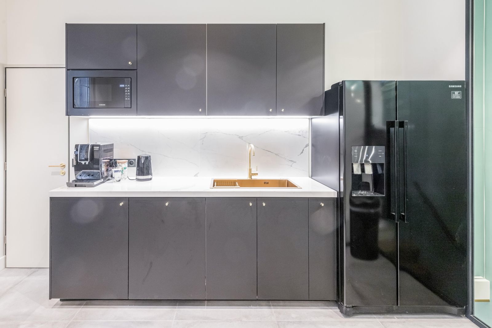 Kitchenette, plan marbre, mitigeur laiton et frigo américain