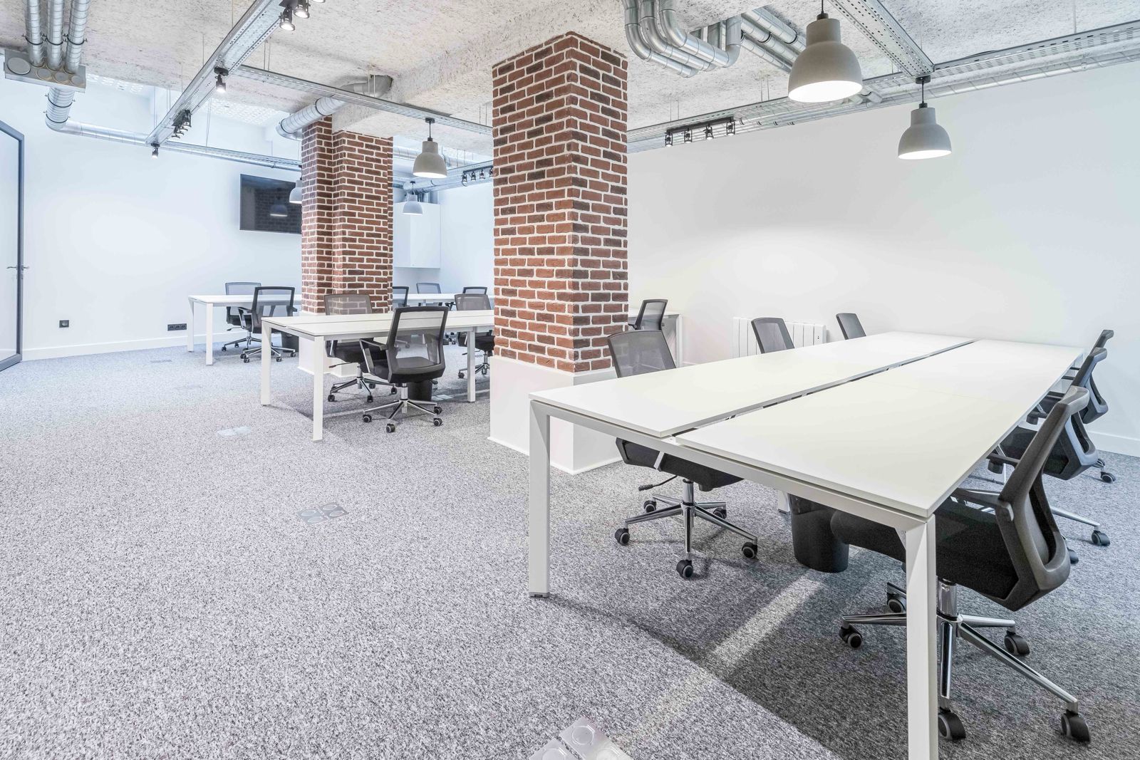 Open-space, piliers en brique et postes en bench